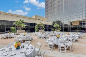 a group of white tables and chairs on a rooftop at Hilton Los Angeles Airport in Los Angeles