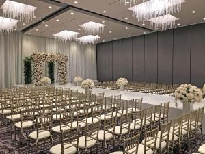a banquet hall with tables and chairs and chandeliers at Hilton Los Angeles Airport in Los Angeles