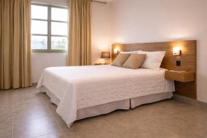 a bedroom with a large white bed with a window at Ph Costa Grande n6 in Nueva Gorgona