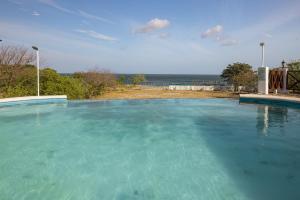 a large pool of blue water with the ocean in the background at Ph Costa Grande n6 in Nueva Gorgona