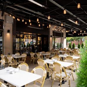 an empty restaurant with white tables and chairs at Hilton Orrington/Evanston in Evanston