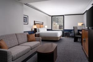 a living room with a couch and a bed at Hilton Orrington/Evanston in Evanston