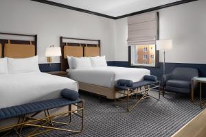 a hotel room with two beds and two chairs at Hilton Orrington/Evanston in Evanston +174 photos