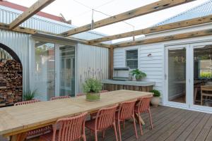 an outdoor patio with a wooden table and chairs at Greta Cottage, Berry in Berry
