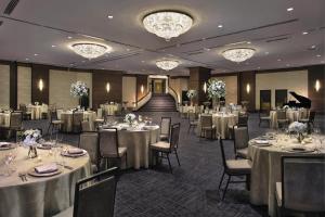 a banquet room with tables and chairs and a piano at Hilton Orrington/Evanston in Evanston