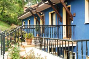 a blue house with a balcony with potted plants at Apartamentos Rurales Les Mestes in Tazones