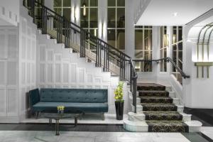 a lobby with a green couch and stairs at Hilton Prague Old Town in Prague