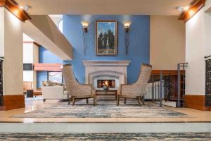 a living room with a fireplace and two chairs at DoubleTree by Hilton Sonoma Wine Country in Rohnert Park