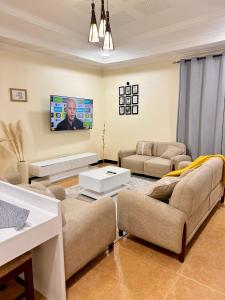 a living room with couches and a flat screen tv at Jefes Haven in Dar es Salaam