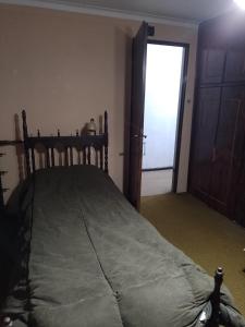 a bedroom with a bed and a door with a window at La casa del recho in Santo Tomé