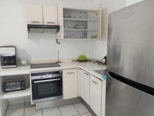 a kitchen with white cabinets and a stainless steel refrigerator at Sierra 5 in Acapulco +2 photos
