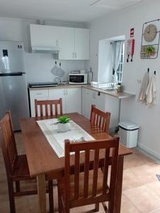 a kitchen with a wooden dining table and chairs at Vista Pico House in Madalena