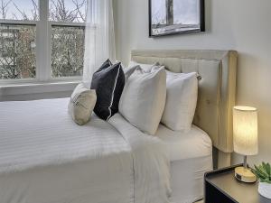 a bedroom with a white bed with pillows at The Orenco Station Hotel in Hillsboro