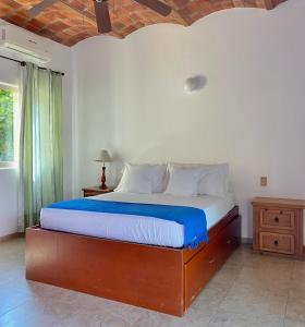 a bedroom with a bed with a blue and white sheets at Casa Del Sol in Lo de Marcos +18 photos