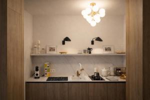 a kitchen with a counter with a sink and a chandelier at Oficyna Drukarza in Wschowa