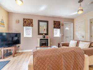 a living room with a couch and a television at Ted's Place in Bridlington