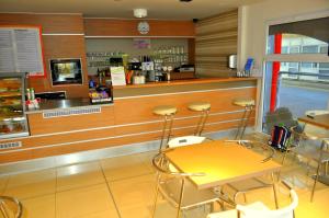 a restaurant with a counter with stools in front of it at GAS Truck centrum in Holíč