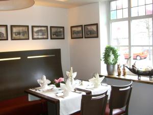 a dining room table with two chairs in front of it at Hotel Osterkrug in Husum