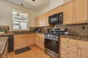 a kitchen with wooden cabinets and a stove top oven at The Orenco Station Hotel in Hillsboro