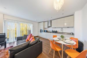 a living room with a couch and a table and chairs at Stylish long & short stay flat with parking & Wifi sleeps 5 in Maidstone