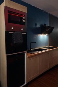 a kitchen with a stove and a microwave at L'Envers SPA - Suite Romantique Metz Centre in Metz