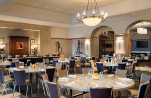 a dining room with tables and chairs and a chandelier at Hilton Santa Clara - Newly Renovated in Santa Clara
