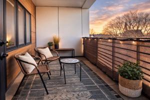 a patio with two chairs and a table on a balcony at East Side Luxury 1BR Apt - Near Brady St with Balcony and Lounge - Sleeps 4 in Milwaukee