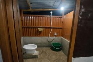 a bathroom with a toilet and a green bucket at Beatus Residence San Isidro in New Agutaya