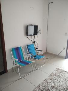 two chairs and a tv in a room at Pousada Aconchego in São Mateus