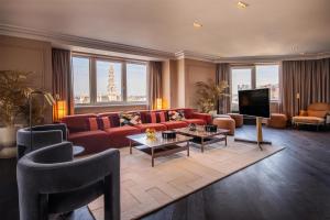 a living room with a red couch and a tv at Hilton Brussels Grand Place in Brussels