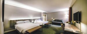 a hotel room with two beds and a desk at Hilton Brussels Grand Place in Brussels +80 photos