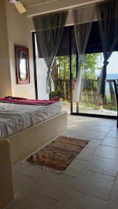 a bedroom with a bed and a view of a patio at Casa Jasmin Bed & Breakfast in Troncones
