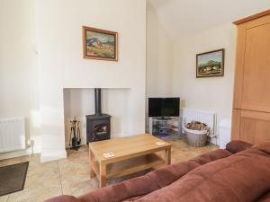 a living room with a couch and a fireplace at Derg Cottage in Strabane