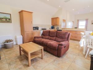 a living room with a brown couch and a table at Derg Cottage in Strabane +10 photos