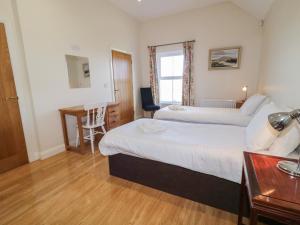 a hotel room with two beds and a desk at Derg Cottage in Strabane