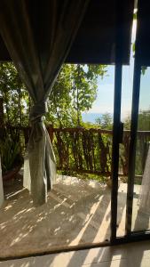 a view from a window of a porch with a curtain at Casa Jasmin Bed & Breakfast in Troncones