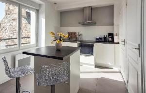 a kitchen with a counter with a vase of flowers on it at Kerarmoor in Plouhinec