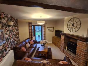 a living room with a couch and a fireplace at Dairy Cottage in Carnforth