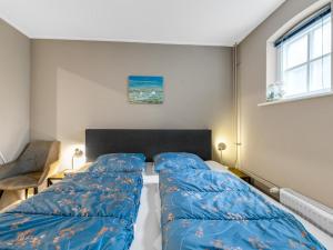 a bedroom with a bed with blue sheets on it at Rutershoeske in Veendam
