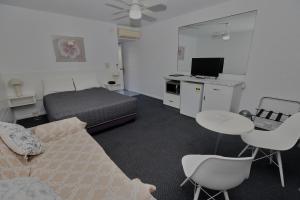 a bedroom with a bed and a table and chairs at Dalby Manor Motor Inn in Dalby