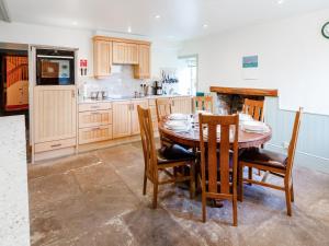 a kitchen with a wooden table and chairs and a kitchen with a counter at Steppe Haugh in Hawes +34 photos