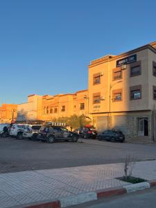 a parking lot with cars parked in front of a building at Jaddou Home in Midelt +16 photos