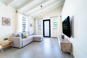 a living room with a couch and a flat screen tv at Casa Norma in Mayaguez in Hacienda Constanza