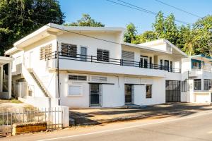 a white house with a fence in front of it at Casa Norma in Mayaguez in Hacienda Constanza