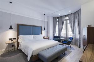 a hotel room with a bed and a table and chairs at DoubleTree by Hilton Madrid-Prado in Madrid +77 photos