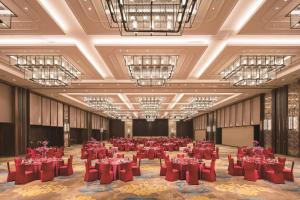 a large banquet hall with red tables and chairs at Hilton Fuzhou in Fuzhou +69 photos