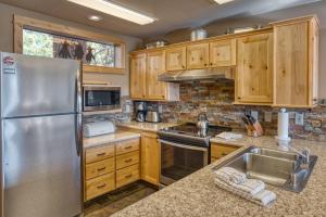 a kitchen with wooden cabinets and a stainless steel refrigerator at Lodge Condo 001 in Black Butte Ranch