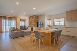 a kitchen and living room with a table and chairs at Granja Beach Front in São Félix da Marinha