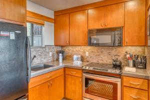 a kitchen with wooden cabinets and a stainless steel refrigerator at Lodge Condo 022 in Black Butte Ranch
