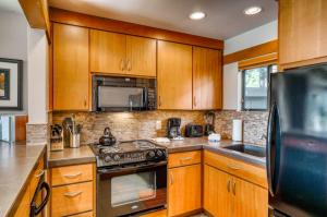 a kitchen with wooden cabinets and a stove top oven at Lodge Condo 021 in Black Butte Ranch